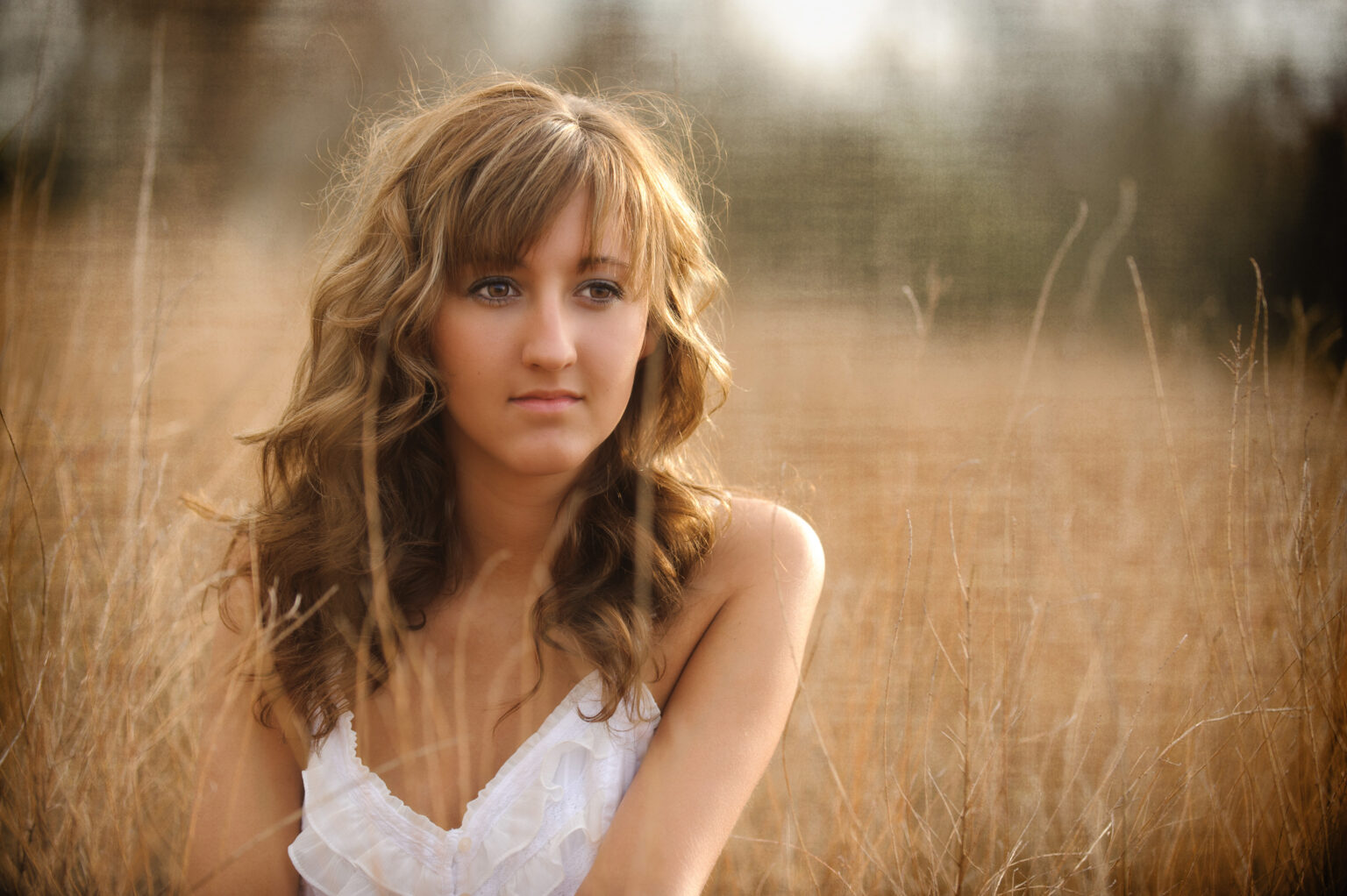 Senior Photos of a girl sitting in a field in evansville indiana
